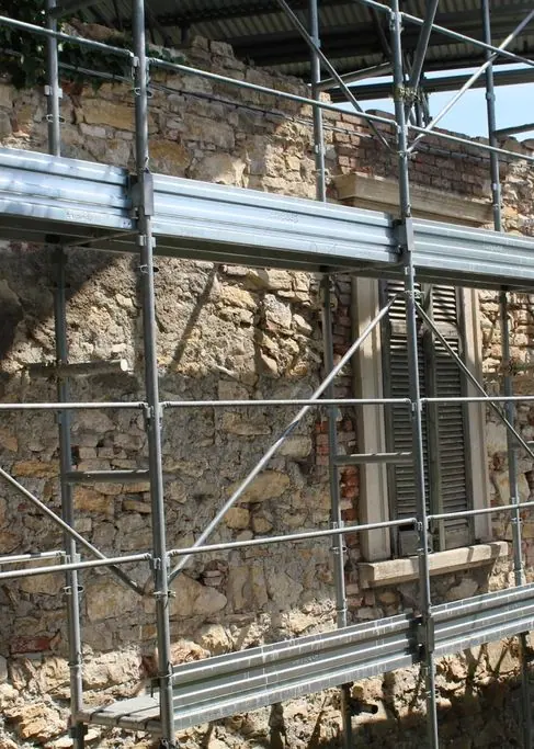Échafaudage dressé devant un mur de pierre en rénovation